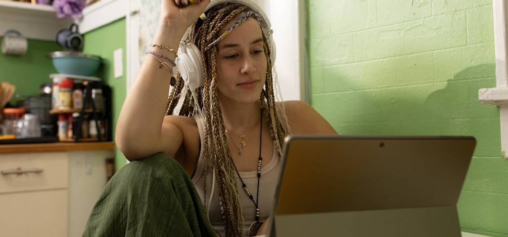 a woman with dreadlocks sitting in front of a laptop computer