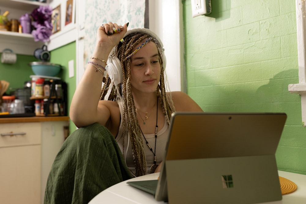 Una donna con i dreadlocks seduta davanti a un computer portatile