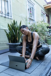 a woman sitting on the ground using a laptop computer