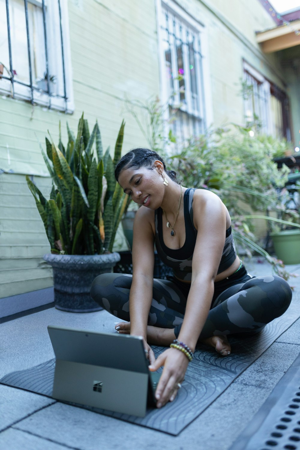 a woman sitting on the ground using a laptop computer