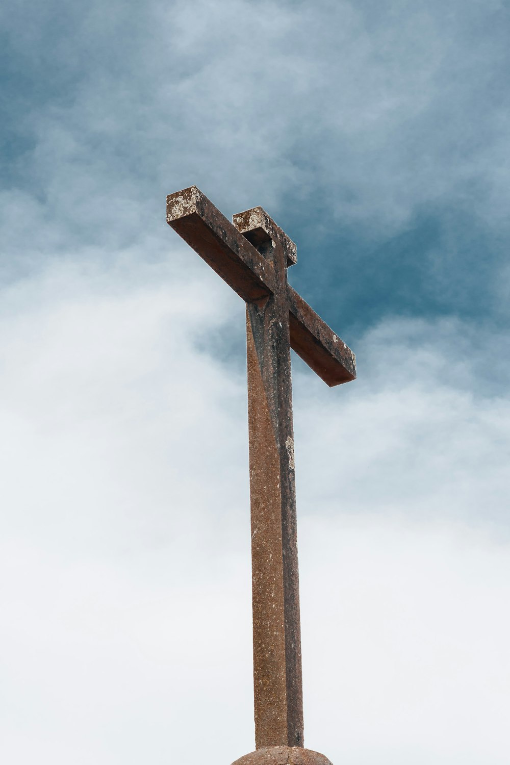 a large wooden cross with a sky background