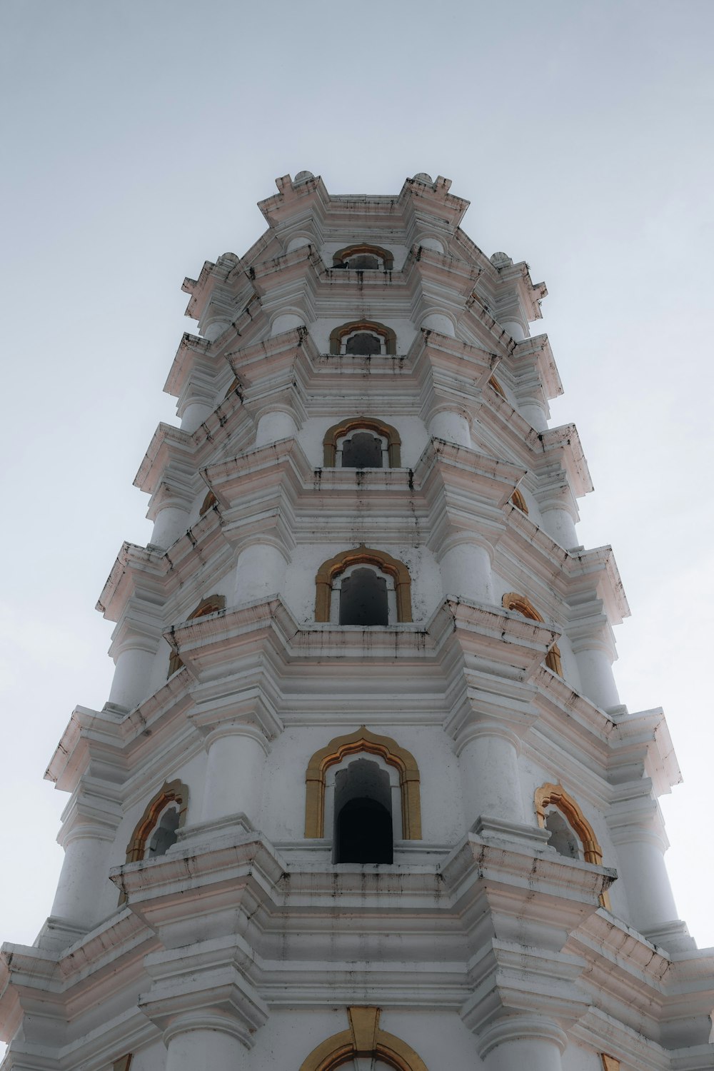 a very tall white building with a clock on it's side