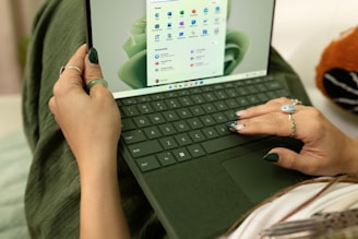 A friendly person typing on a laptop with email and message icons floating around.