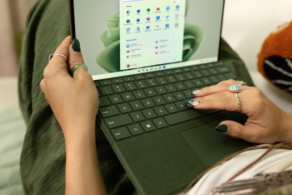A friendly person typing on a laptop with email and message icons floating around.