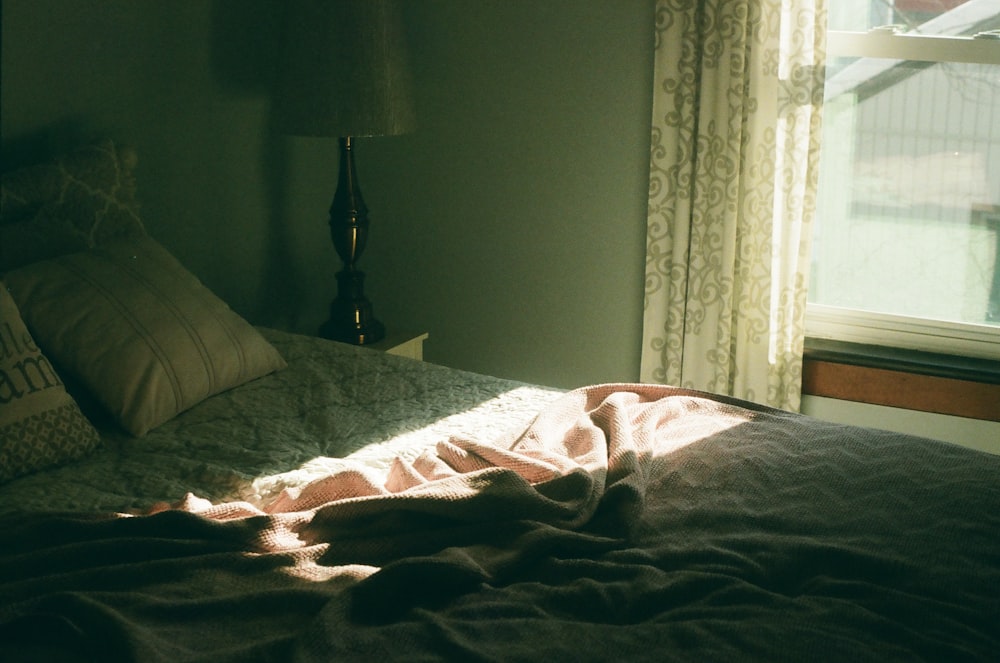 a bed with a blanket on it in a bedroom