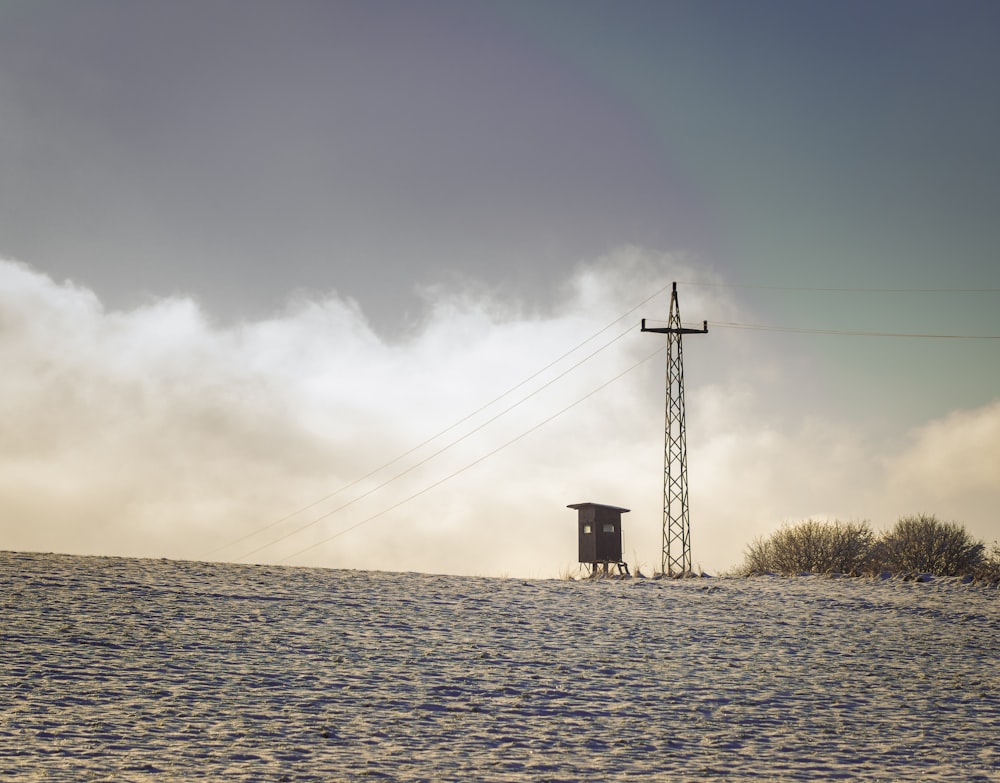 a small building on a hill with a rainbow in the sky