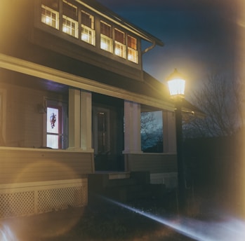 Cozy house with a warm light glowing inside during twilight, representing home insurance security