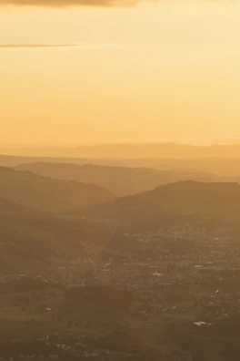 Sunset over the region's rolling hills with warm golden light bathing the landscape.