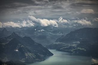 A panoramic view of a misty mountain range in North America with a winding river below.