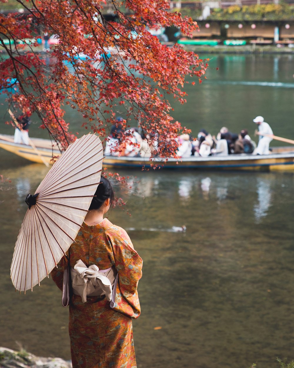 a woman in a kimono is holding an umbrella