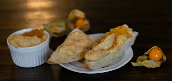 A spoonful of marmalade held above a slice of warm toast with sunlight streaming in