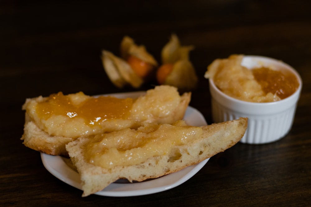 a white plate topped with fried food next to a bowl of dipping sauce