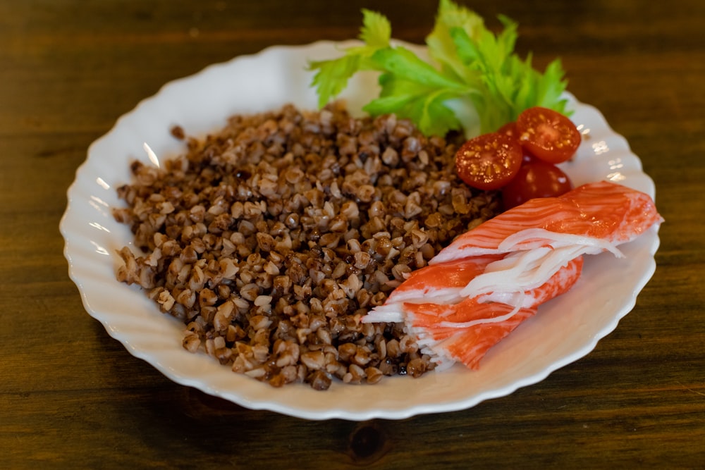 a white plate topped with meat and rice