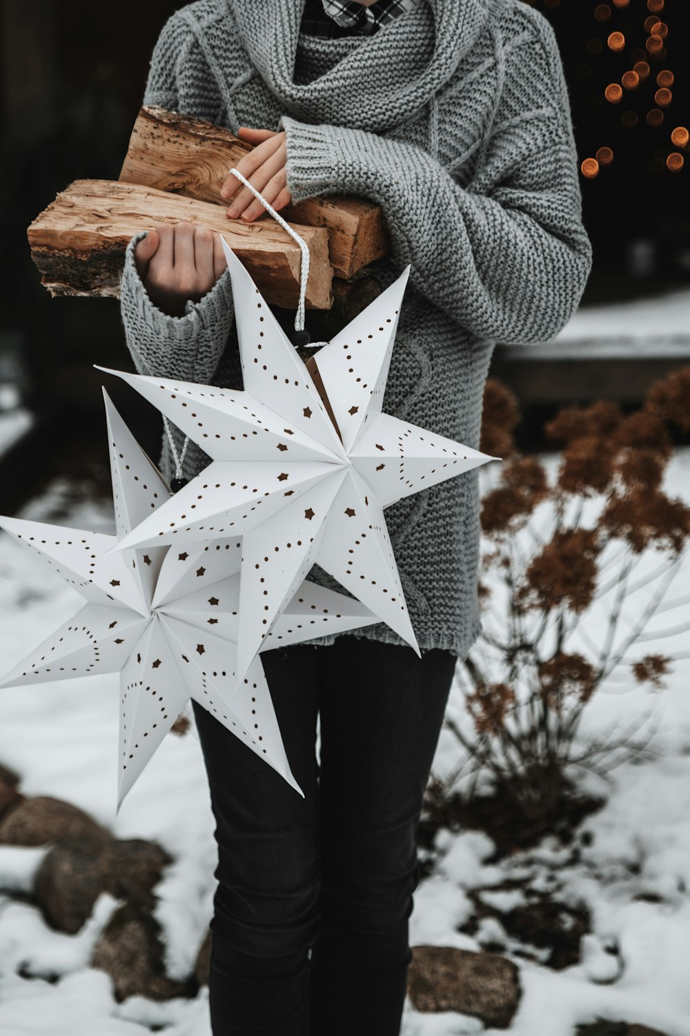 a woman holding a piece of wood and a paper star