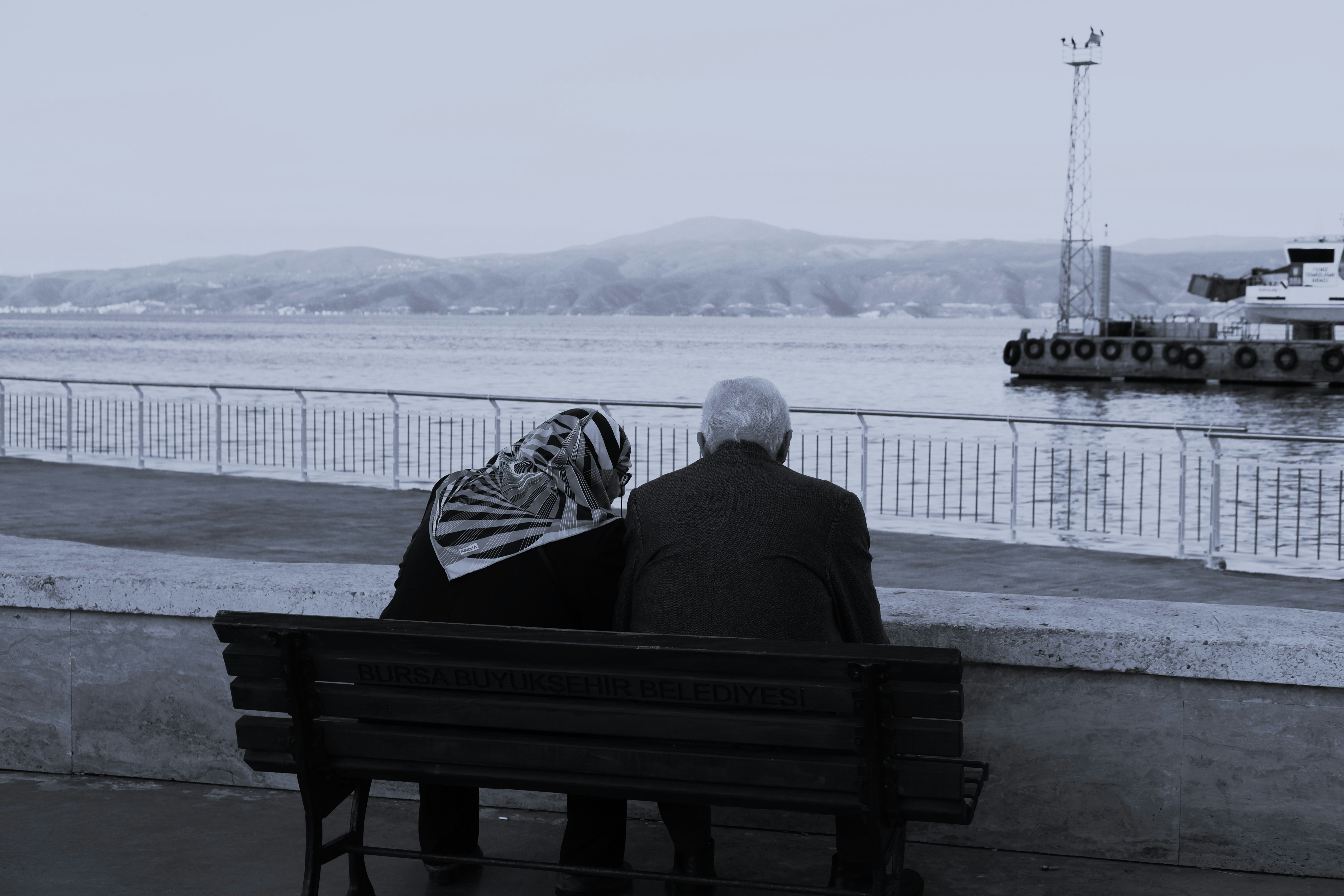 Two people on bench overlooking water