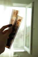 Hands holding a sample strip of window film showing its layered composition.