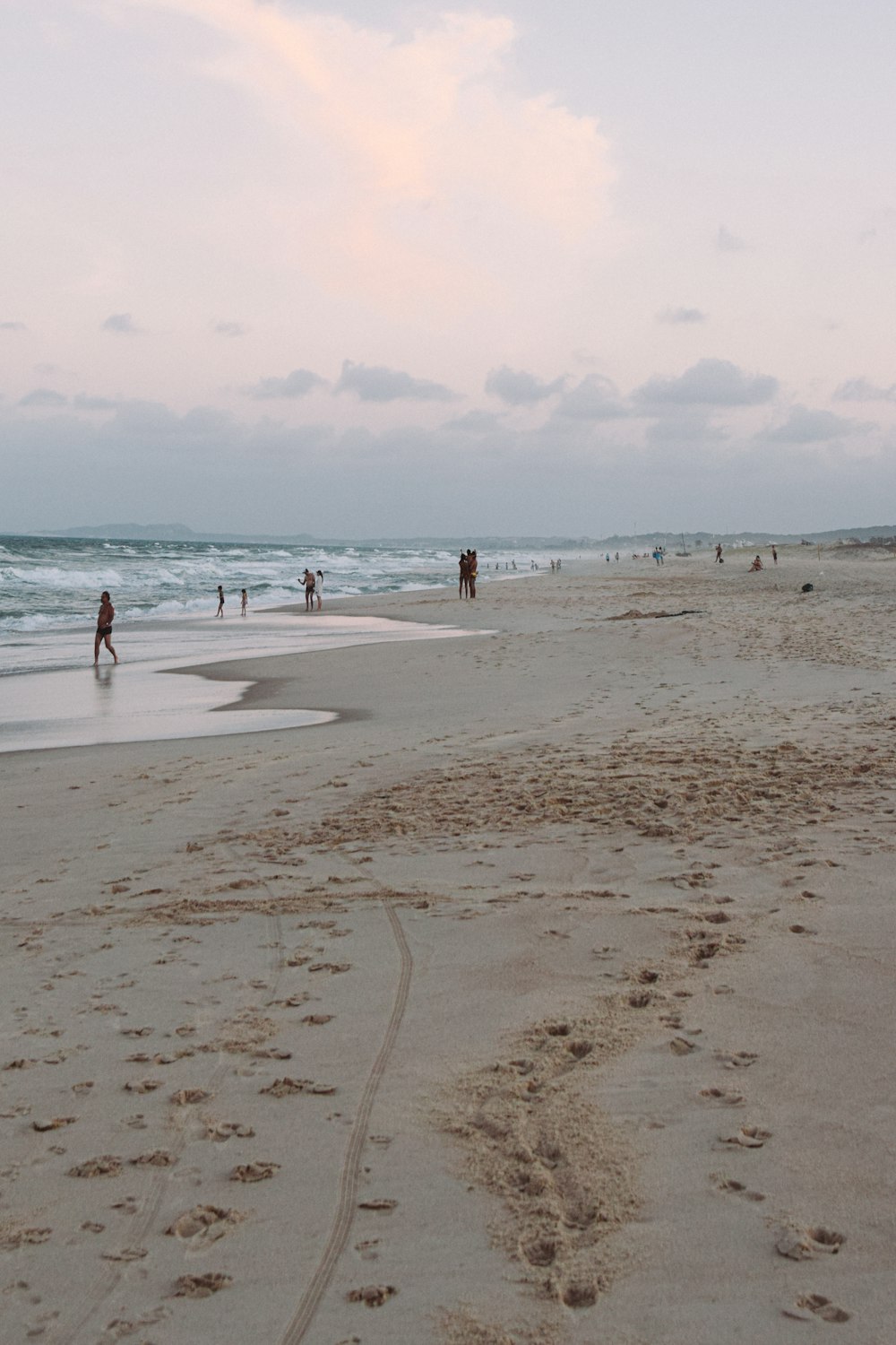 a group of people standing on top of a sandy beach