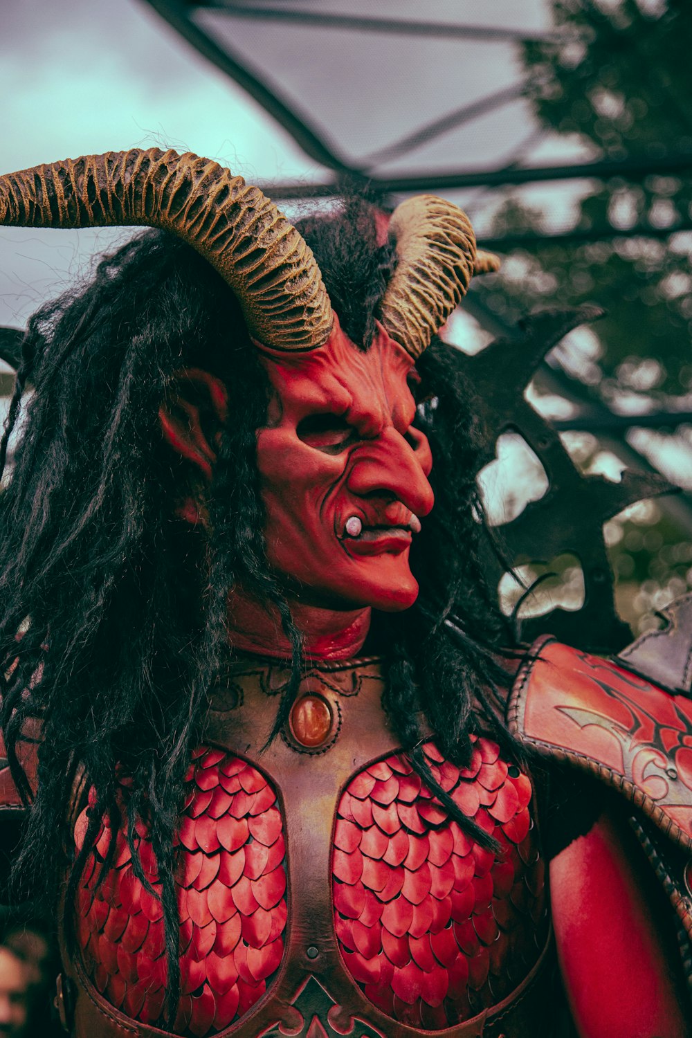 a man dressed in red and black with horns