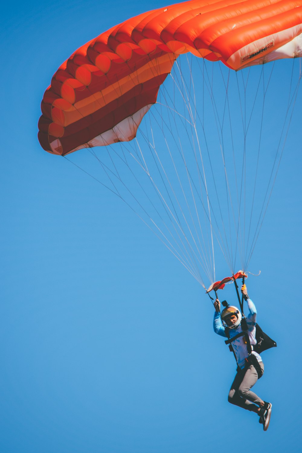 a man flying through the air while holding onto a parachute