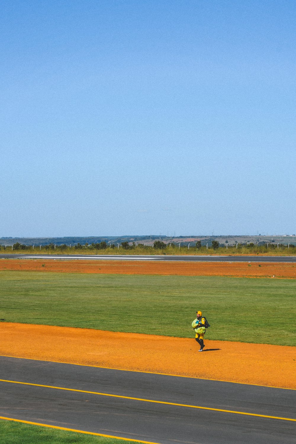 a person running down a road with a kite in the air