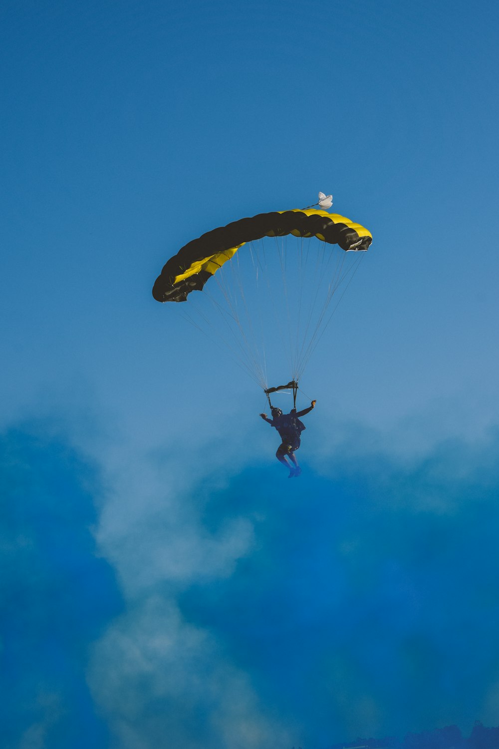 a man flying through the air while holding onto a parachute