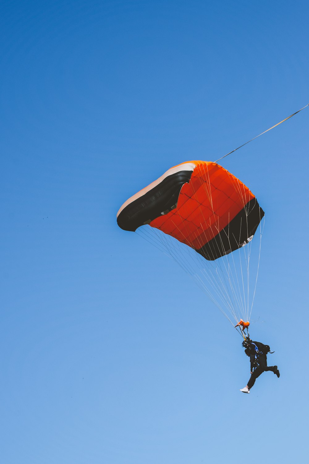 a man flying through the air while holding onto a parachute