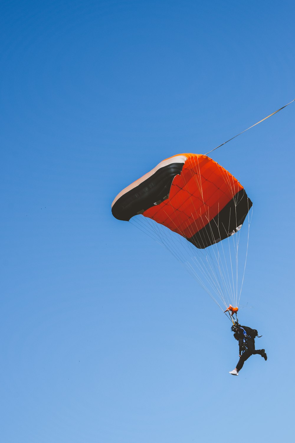 Un hombre volando por el aire mientras se aferra a un paracaídas