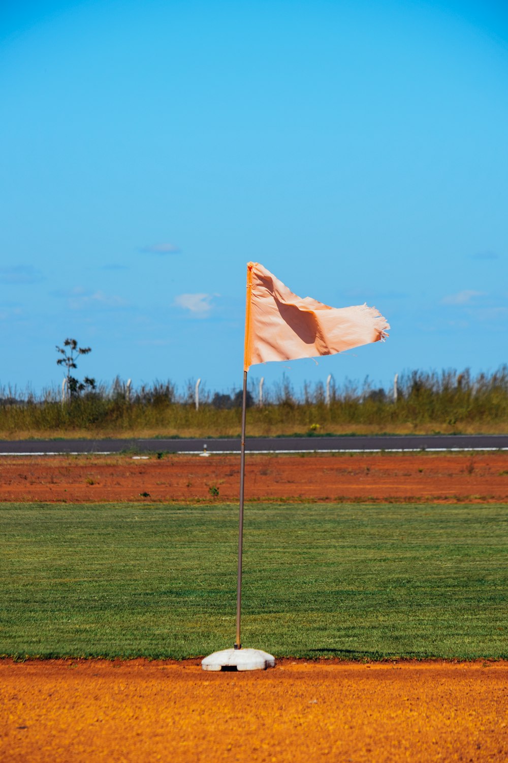 un drapeau sur un terrain de baseball avec une base en terre battue