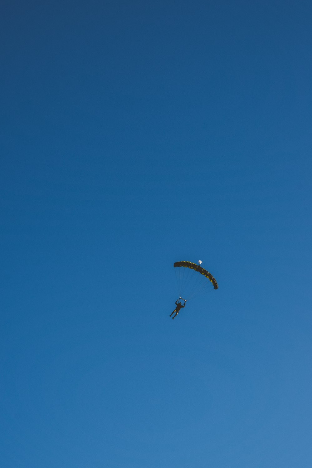 a person is parasailing in the blue sky