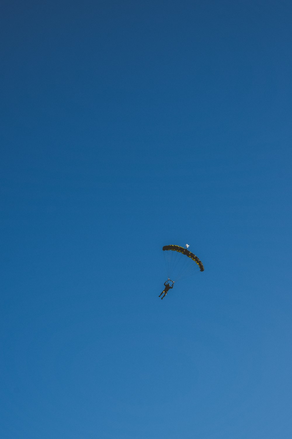 Una persona está haciendo parasailing en el cielo azul