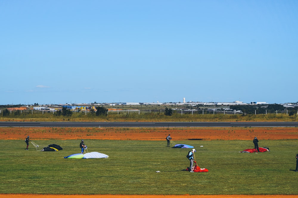 a group of people standing on top of a lush green field