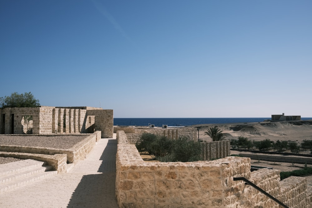 a stone wall and steps leading to the ocean