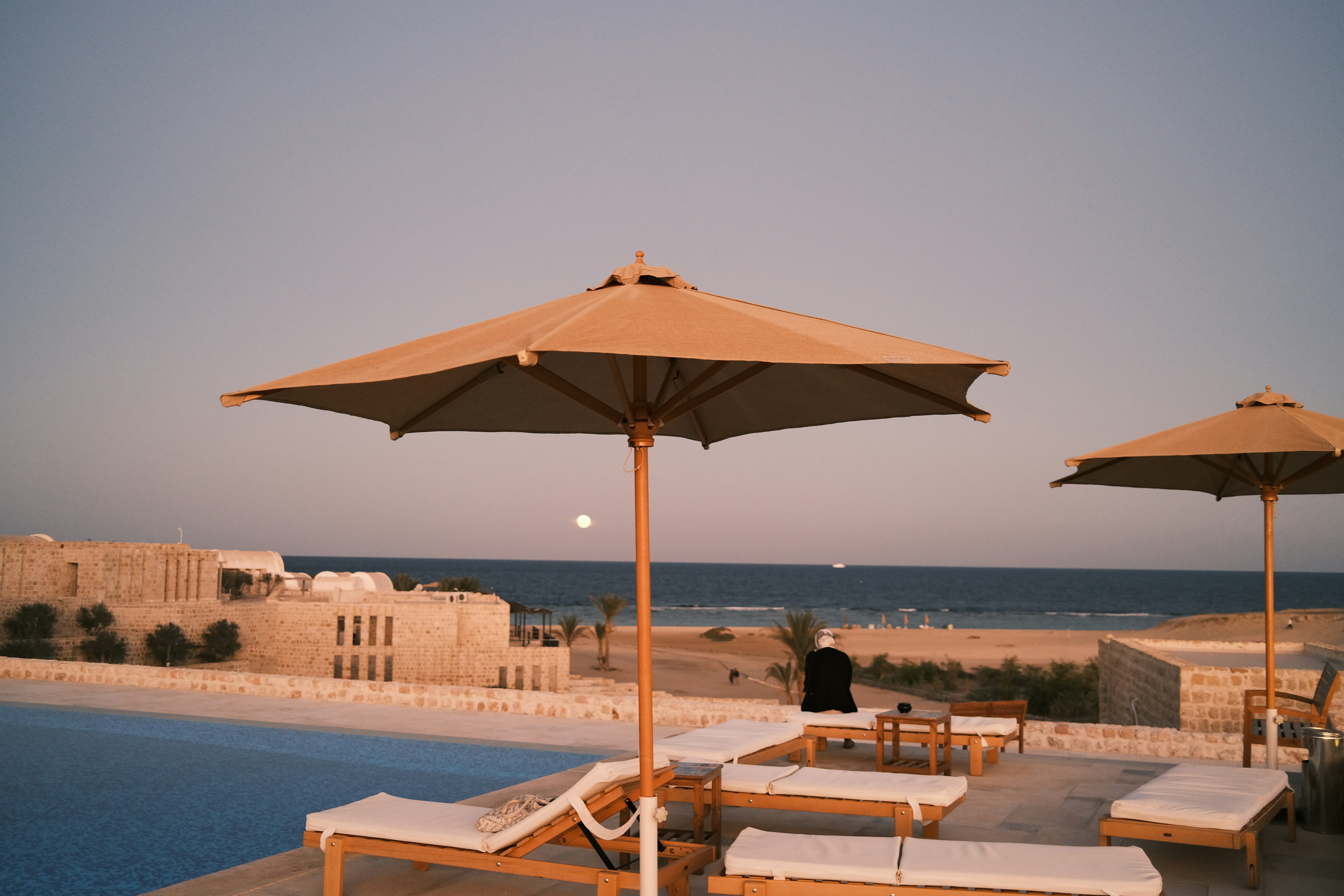 a couple of umbrellas sitting next to a swimming pool, Hotel in Marsa Alam