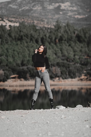 A confident sales representative standing on a mountain trail, overlooking a vast forested valley at sunrise.