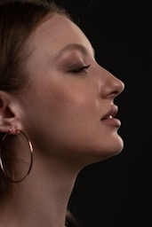 a close up of a person wearing large hoop earrings