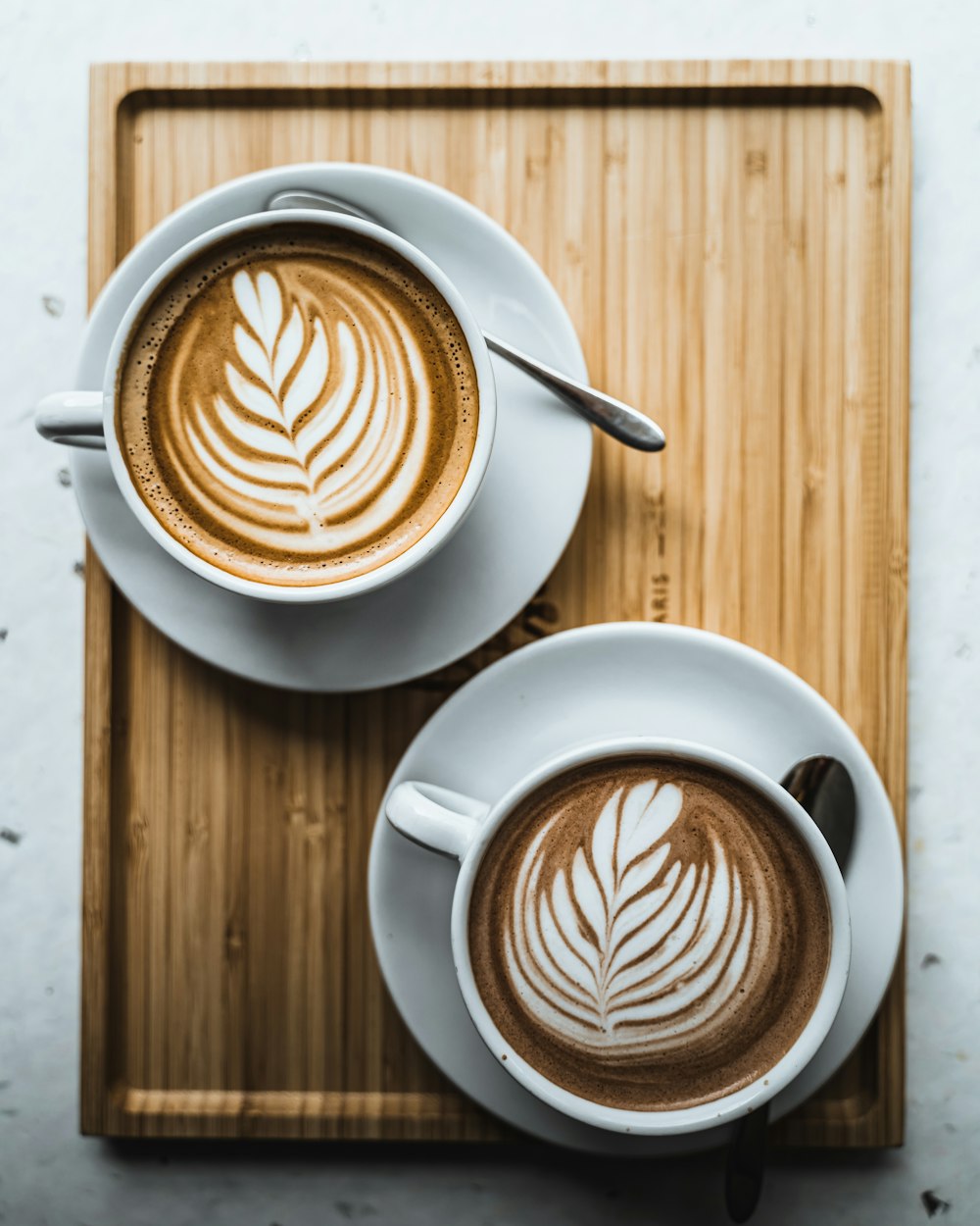 Dos tazas de café en una bandeja de madera