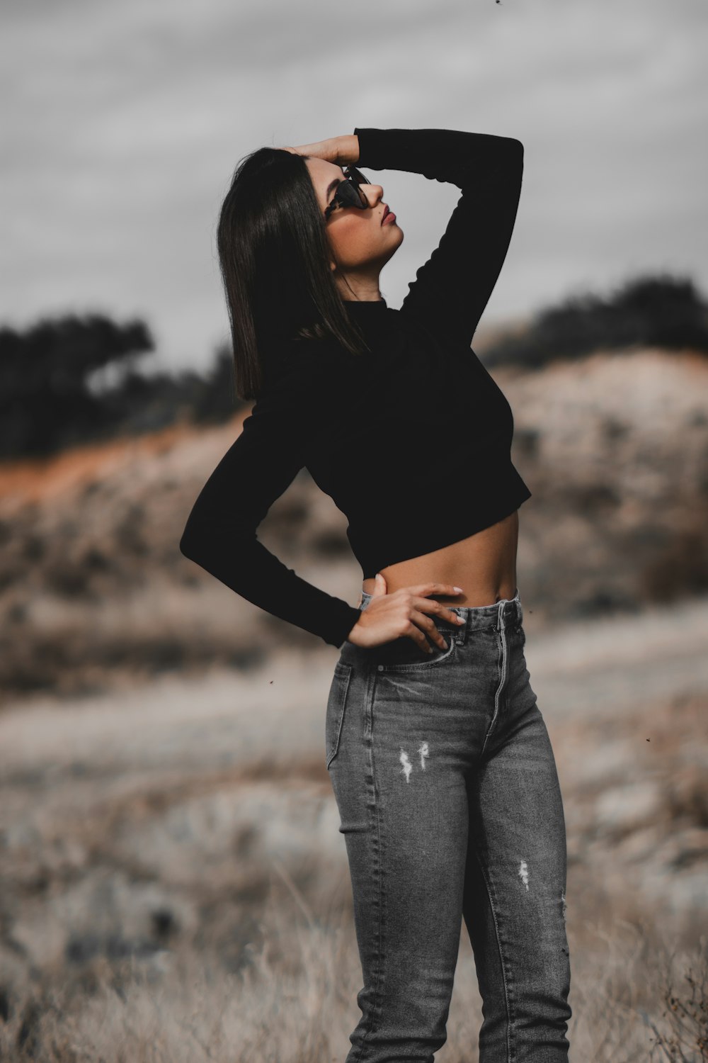 a woman standing in a field with her hands on her hips