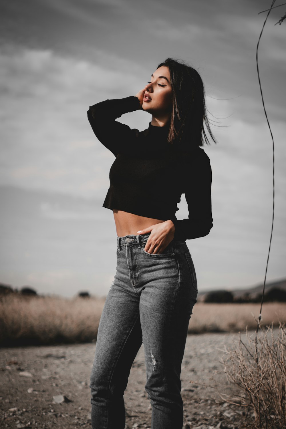 a woman standing in a field with her hands on her hips