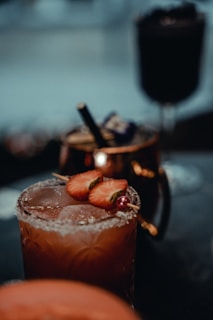 A close-up of a cocktail glass with a decorative rim and fruit slice.