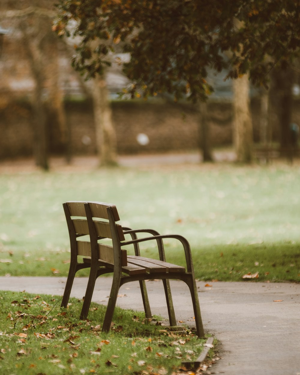 a park bench sitting on the side of a sidewalk