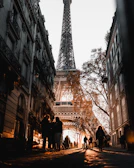 Charming street scene in Paris with cafe tables and the Eiffel Tower in the background during sunset