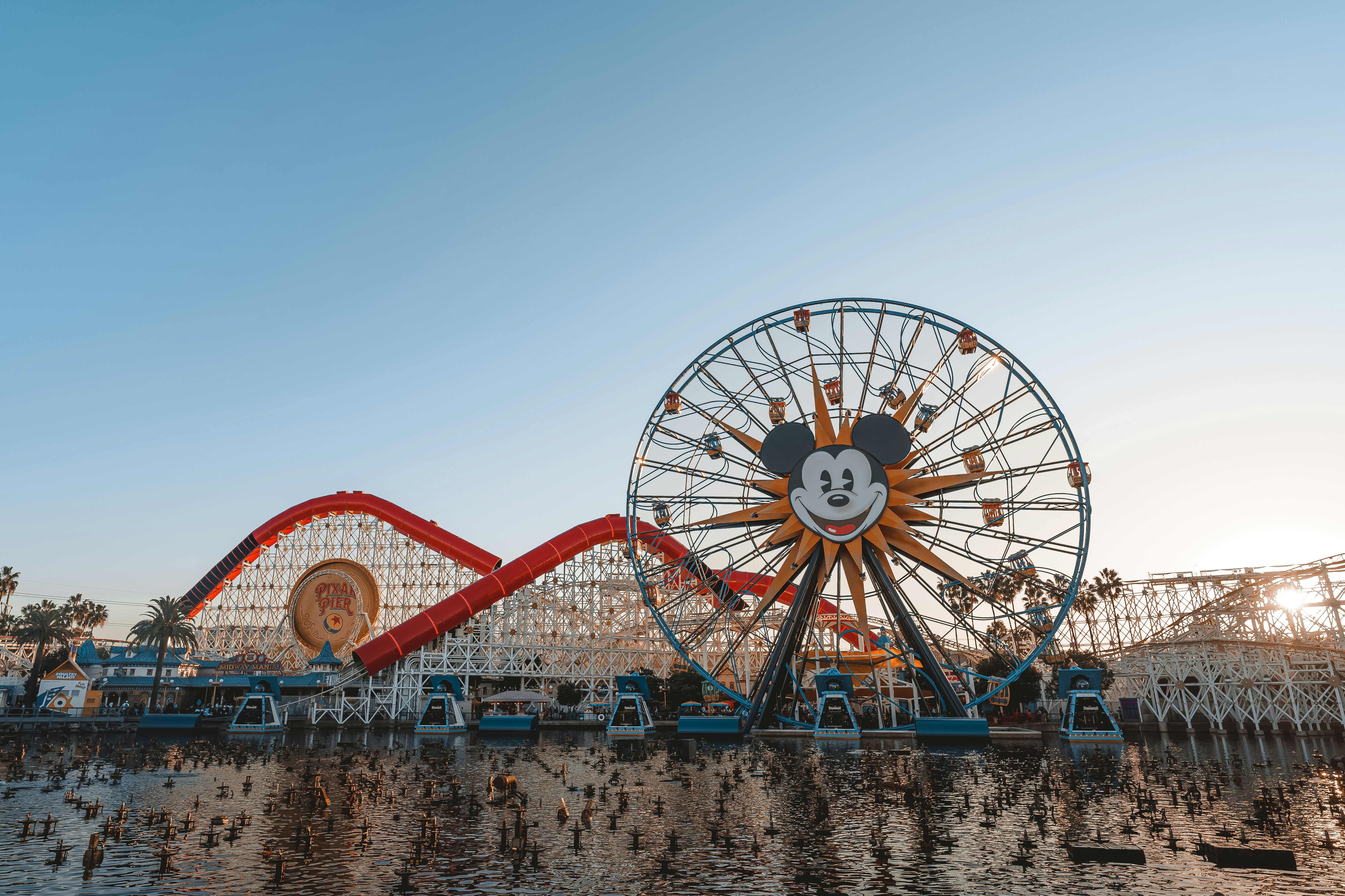 a large ferris wheel sitting next to a lake, 