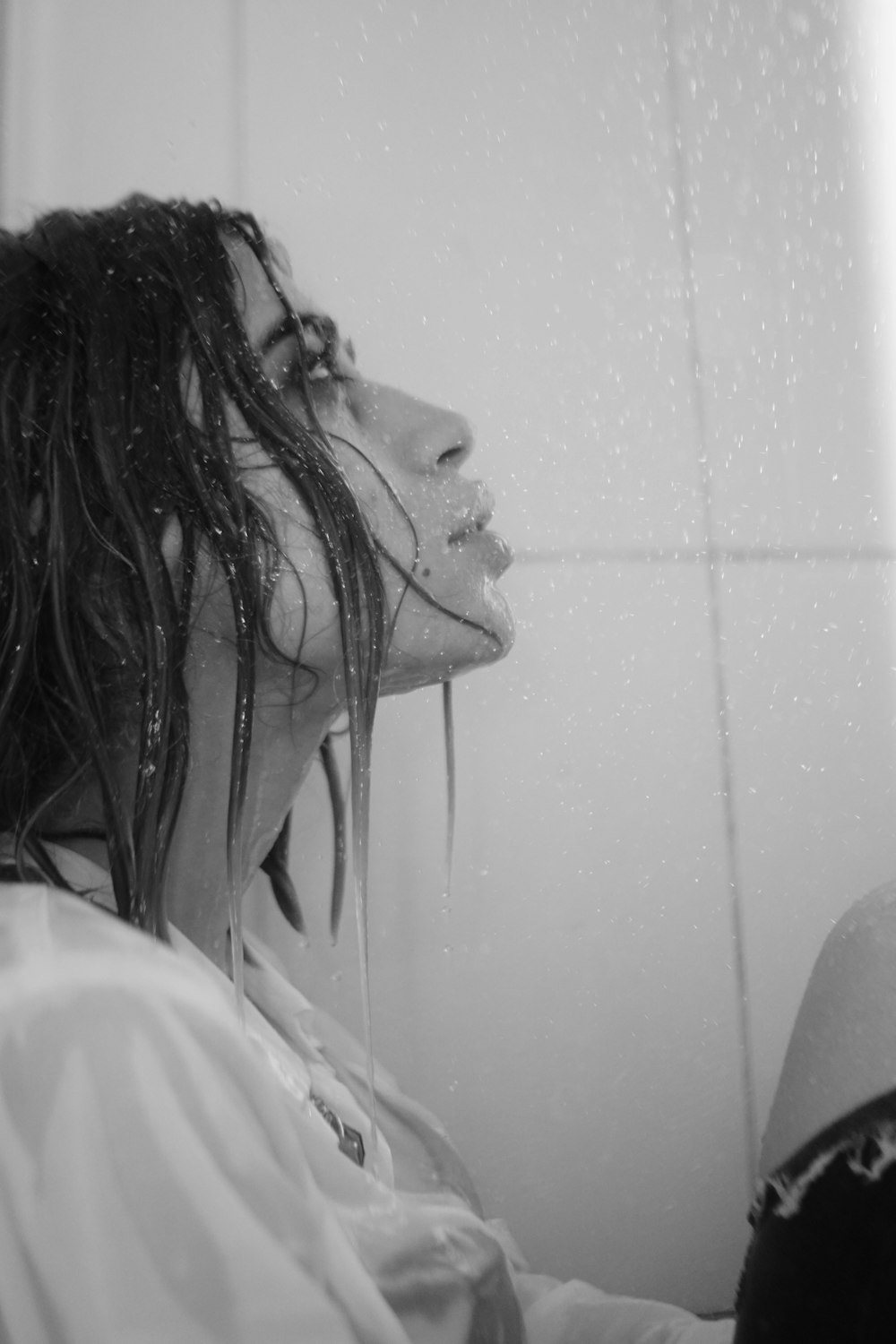 a woman with dreadlocks sitting in front of a shower