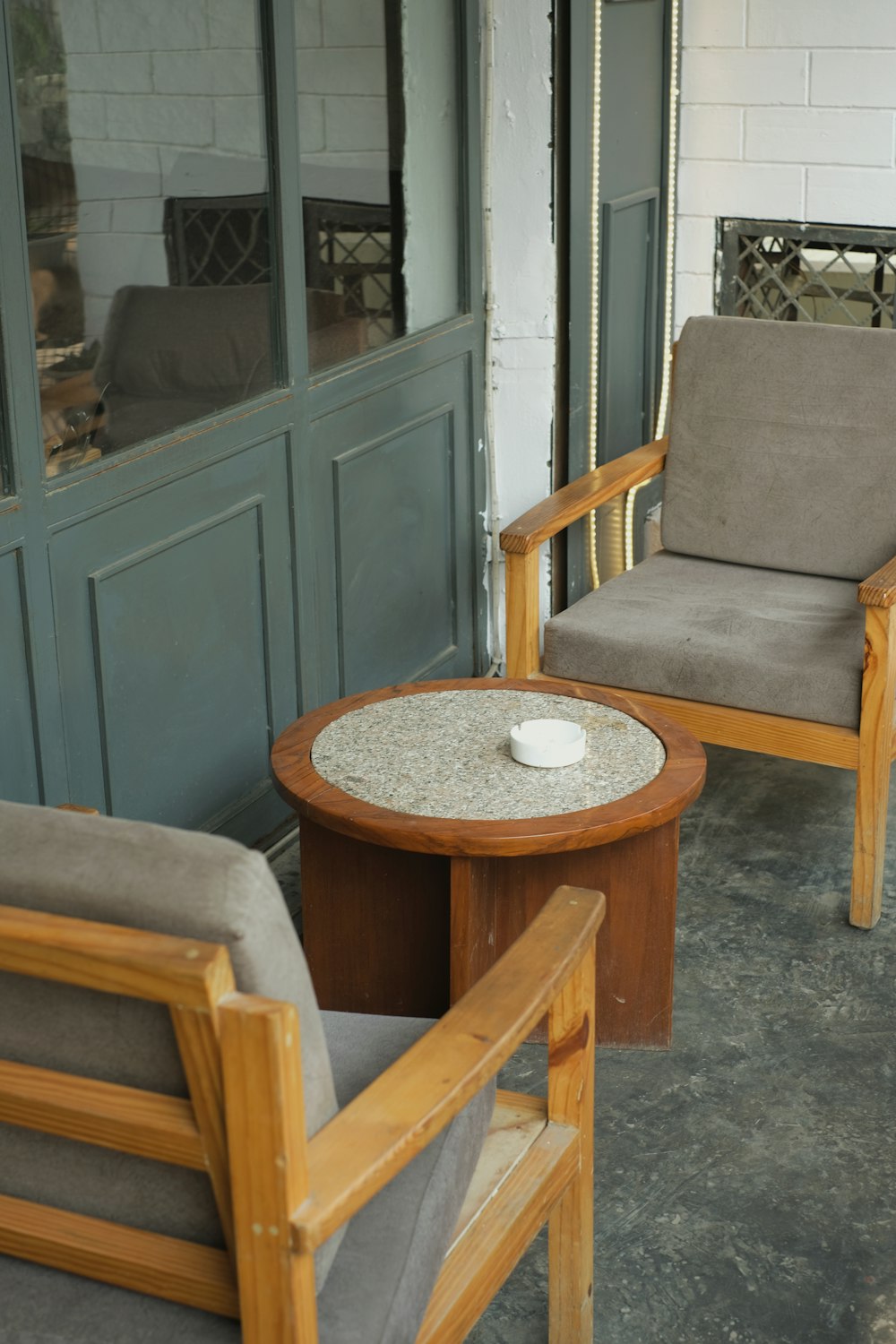 two chairs and a table on a porch