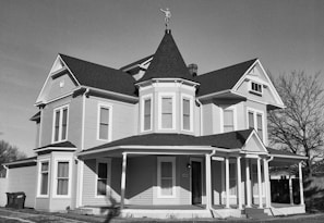 Before and after photo of a renovated Victorian house with fresh paint and new windows.