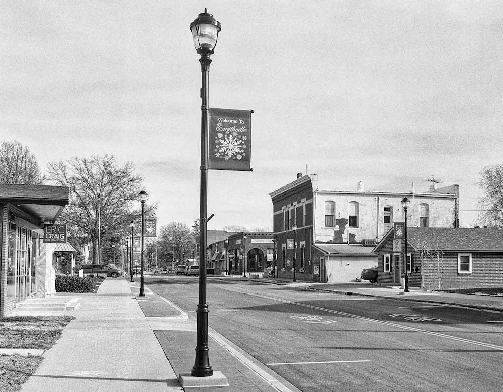 a black and white photo of a clock on a pole