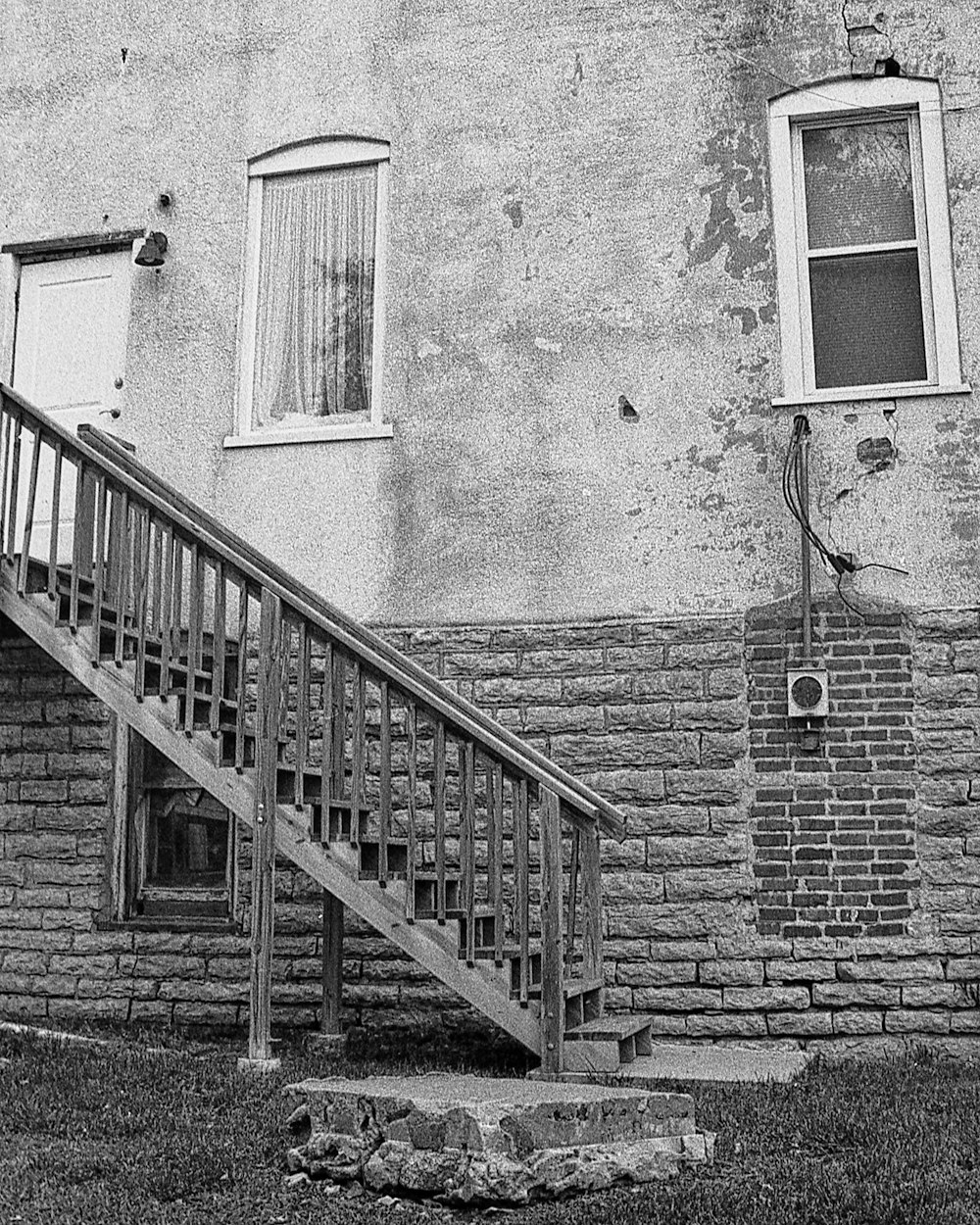 a black and white photo of a brick building with a stair case