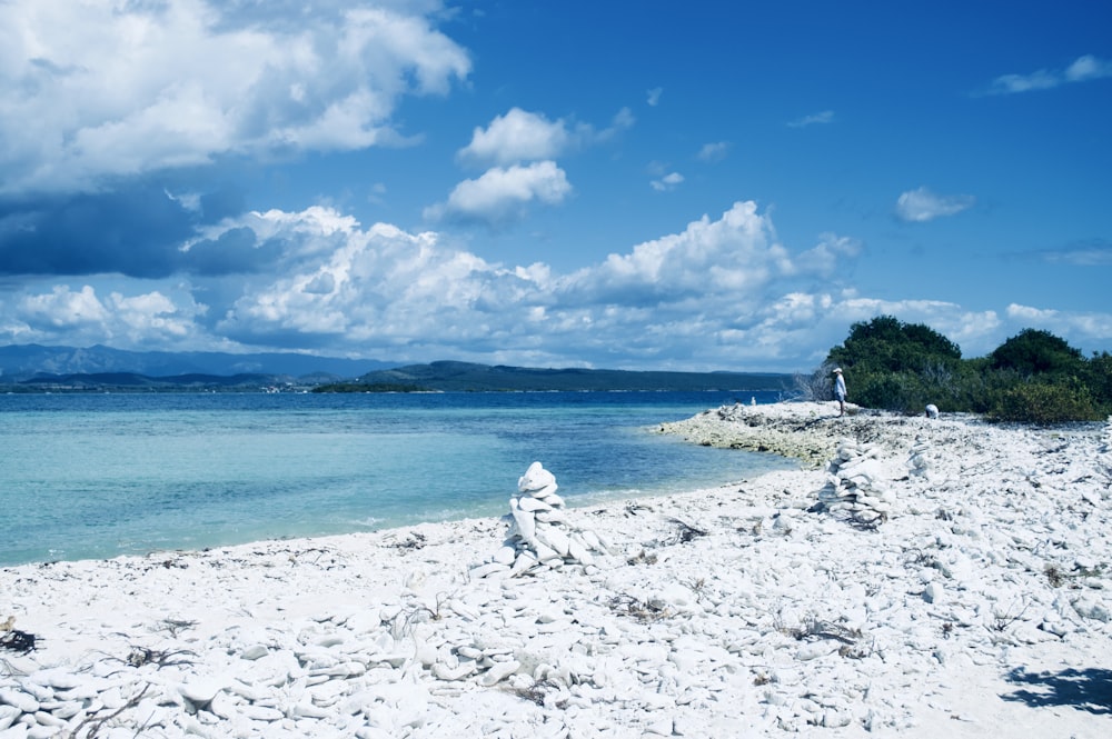 a sandy beach next to a body of water