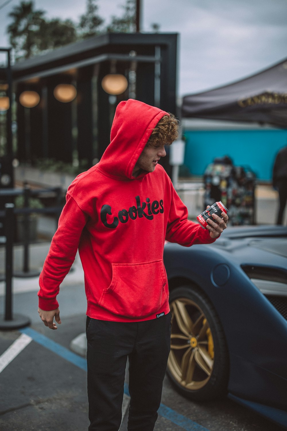 a man in a red hoodie looking at his cell phone
