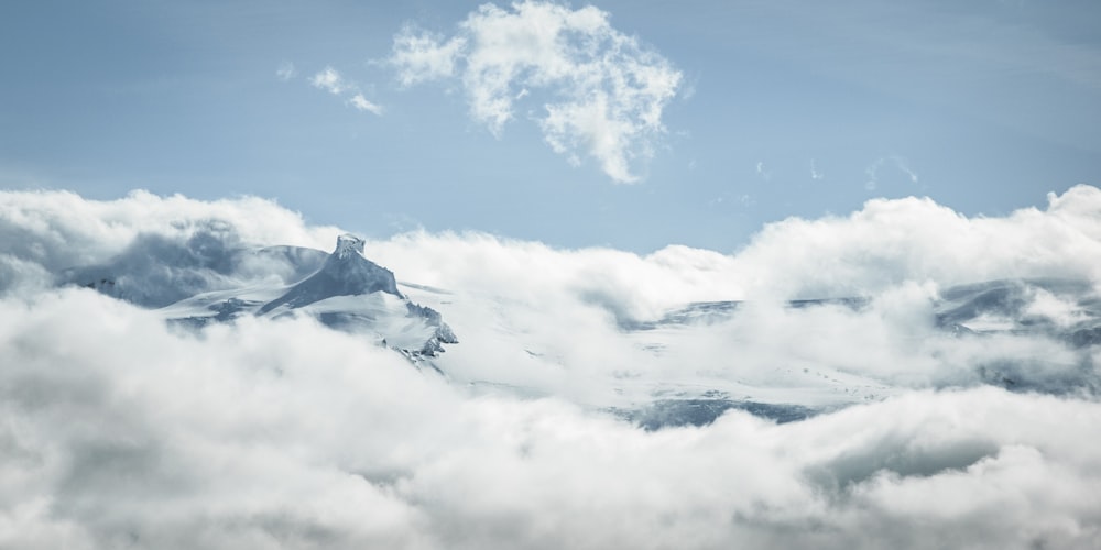 Una montaña cubierta de nubes bajo un cielo azul